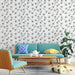 Un salon moderne avec un papier peint floral noir et blanc représentant des fleurs délicates sur fond clair, créant une atmosphère élégante et apaisante.