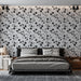 Une chambre moderne avec un papier peint floral noir et blanc, présentant des motifs élégants de fleurs sur fond clair, créant une atmosphère chic et apaisante.