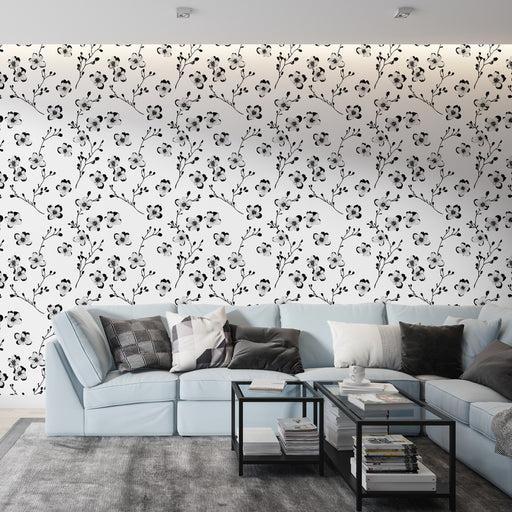 Un salon moderne avec un papier peint floral en noir et blanc, aux motifs délicats de fleurs et de branches, créant une ambiance élégante et apaisante.