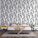 Une chambre moderne avec un papier peint floral noir et blanc représentant des branches délicates, créant une atmosphère élégante et apaisante.