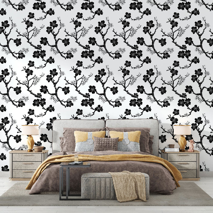 Une chambre élégante avec un papier peint noir et blanc représentant des branches fleuries, créant une atmosphère artistique et apaisante.