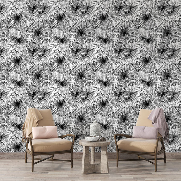 Un salon élégant avec un papier peint floral noir et blanc, présentant de grandes fleurs stylisées qui créent une ambiance artistique et contemporaine.