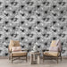 Un salon élégant avec un papier peint floral noir et blanc, présentant de grandes fleurs stylisées qui créent une ambiance artistique et contemporaine.