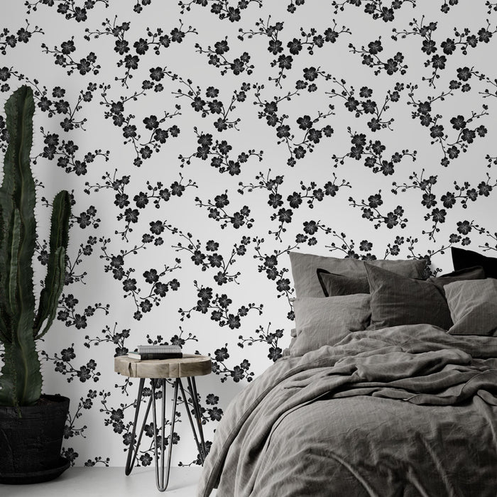 Une chambre moderne avec un papier peint floral noir sur fond blanc, créant une atmosphère élégante et apaisante.