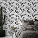 Une chambre moderne avec un papier peint floral noir sur fond blanc, créant une atmosphère élégante et apaisante.