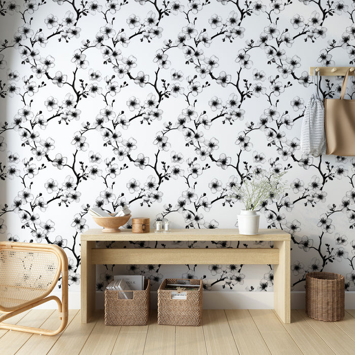 Une entrée lumineuse avec un papier peint floral noir et blanc représentant des branches de fleurs délicates, créant une atmosphère élégante et apaisante.