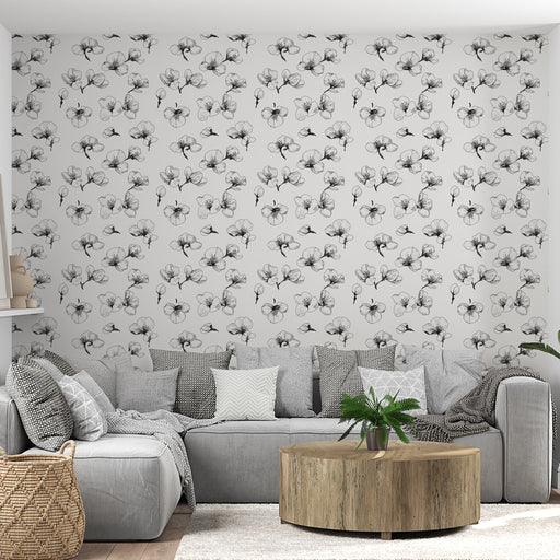 Un salon moderne avec un papier peint floral en noir et blanc, présentant des motifs délicats de fleurs sur fond clair, créant une ambiance élégante et apaisante.