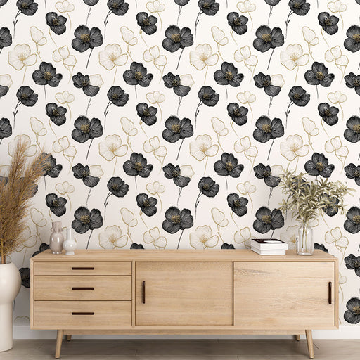 Une salle de séjour élégante avec un papier peint floral noir et doré sur fond clair, créant une atmosphère artistique et raffinée.