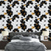 Une chambre moderne avec un papier peint floral en noir, blanc et touches dorées, créant une atmosphère élégante et dynamique.