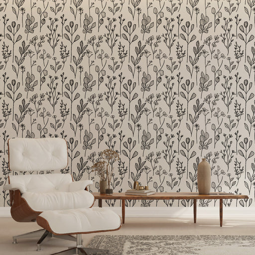 Un salon élégant avec un papier peint floral noir sur fond clair, créant une ambiance apaisante et naturelle grâce à ses motifs délicats de plantes.