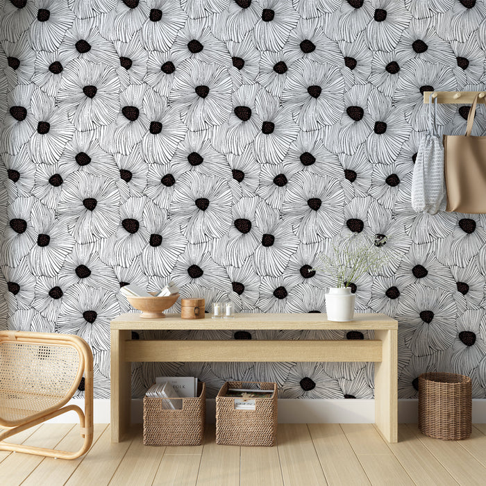 Une pièce lumineuse avec un papier peint floral noir et blanc, présentant de grandes fleurs stylisées qui créent une atmosphère artistique et moderne.