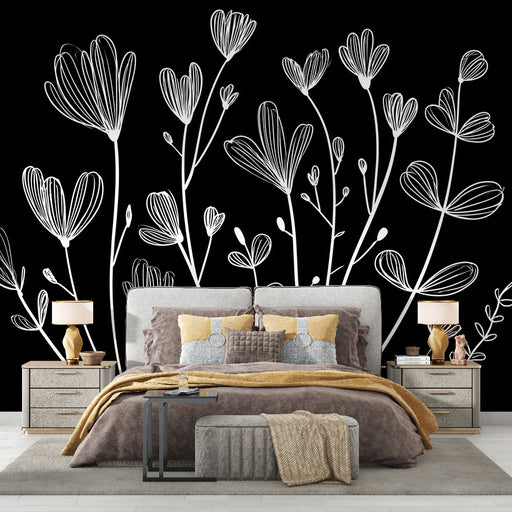 Une chambre élégante avec un papier peint floral blanc sur fond noir, créant une atmosphère moderne et artistique.