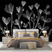 Une chambre élégante avec un papier peint floral blanc sur fond noir, créant une atmosphère moderne et artistique.