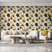 Un salon moderne avec un papier peint floral noir et jaune sur fond blanc, créant une ambiance joyeuse et dynamique.