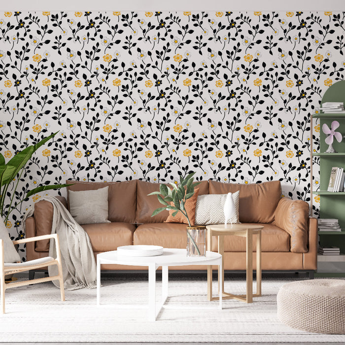Un salon chaleureux avec un papier peint floral aux motifs noirs et jaunes sur fond blanc, créant une ambiance joyeuse et accueillante.