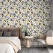 Une chambre élégante avec un papier peint floral noir et jaune sur fond blanc, créant une ambiance dynamique et joyeuse.