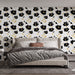 Une chambre élégante avec un papier peint floral noir et doré sur fond blanc, créant une atmosphère chic et apaisante.
