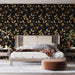 Une chambre moderne avec un papier peint floral noir et doré, aux motifs de fleurs et feuilles, créant une ambiance élégante et chaleureuse.