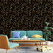 Un salon moderne avec un papier peint floral noir et doré, aux motifs élégants de plantes, créant une atmosphère sophistiquée et chaleureuse.