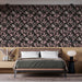 Une chambre élégante avec un papier peint floral noir aux motifs de feuilles roses et blanches, créant une ambiance chaleureuse et raffinée.