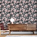 Une pièce moderne avec un papier peint floral noir et rose, orné de grandes fleurs et de feuilles exotiques, créant une ambiance tropicale et vivante.