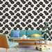 Un salon moderne avec un papier peint floral noir et or sur fond blanc, créant une atmosphère élégante et dynamique.