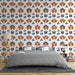 Une chambre moderne avec un papier peint floral aux motifs orange et bleu sur fond blanc, créant une ambiance chaleureuse et accueillante.