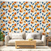 Un salon lumineux avec un papier peint floral aux motifs orange et bleu sur fond crème, créant une ambiance chaleureuse et accueillante.