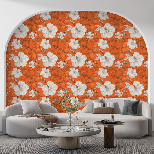 Un salon contemporain avec un papier peint floral orange vif orné de grandes fleurs blanches et de motifs botaniques, créant une atmosphère dynamique et chaleureuse.