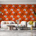 Un salon moderne avec un papier peint floral orange vif orné de grandes fleurs blanches et noires, créant une atmosphère dynamique et chaleureuse.