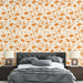 Une chambre moderne avec un papier peint floral orange sur fond crème, créant une atmosphère chaleureuse et accueillante.