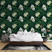 Une chambre apaisante avec un papier peint tropical vert foncé orné de grandes feuilles et d'orchidées blanches, créant une atmosphère naturelle et élégante.