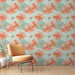 Une chambre lumineuse avec un papier peint floral aux grandes fleurs corail et bleu clair sur fond pastel, créant une ambiance fraîche et joyeuse.