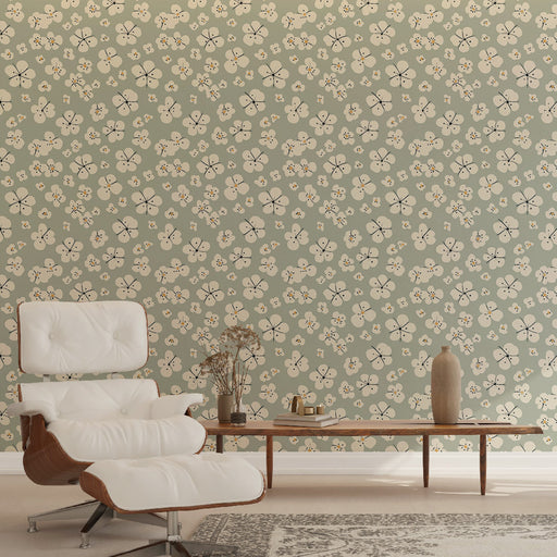 Un salon moderne avec un papier peint floral vert doux orné de petites fleurs blanches et touches dorées, créant une ambiance douce et apaisante.