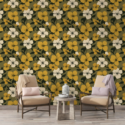 Une pièce accueillante avec un papier peint floral aux grandes fleurs jaunes et blanches sur fond vert olive, créant une atmosphère chaleureuse et naturelle.