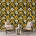 Une pièce accueillante avec un papier peint floral aux grandes fleurs jaunes et blanches sur fond vert olive, créant une atmosphère chaleureuse et naturelle.