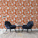Un salon moderne avec un papier peint terracotta orné de motifs floraux blancs, créant une atmosphère chaleureuse et accueillante.