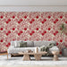 Un salon élégant avec un papier peint floral aux motifs rouges sur fond crème, créant une atmosphère chaleureuse et accueillante.