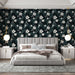 Une chambre moderne avec un papier peint floral sur fond noir, aux motifs de grandes fleurs blanches et feuillages verts, créant une ambiance élégante et apaisante.