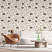 Un salon moderne avec un papier peint floral beige et noir, aux motifs délicats de fleurs stylisées, créant une ambiance douce et élégante.