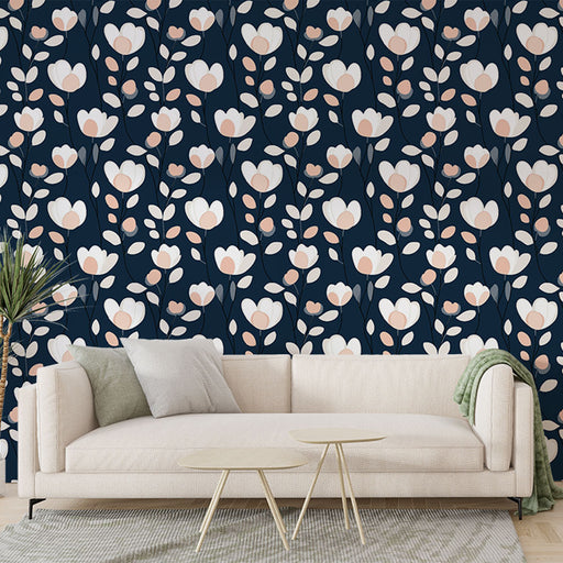 Un salon moderne avec un papier peint floral sur fond bleu marine, présentant de grandes fleurs blanches et des touches de rose, créant une ambiance élégante et apaisante.