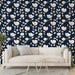 Un salon moderne avec un papier peint floral sur fond bleu marine, présentant de grandes fleurs blanches et des touches de rose, créant une ambiance élégante et apaisante.