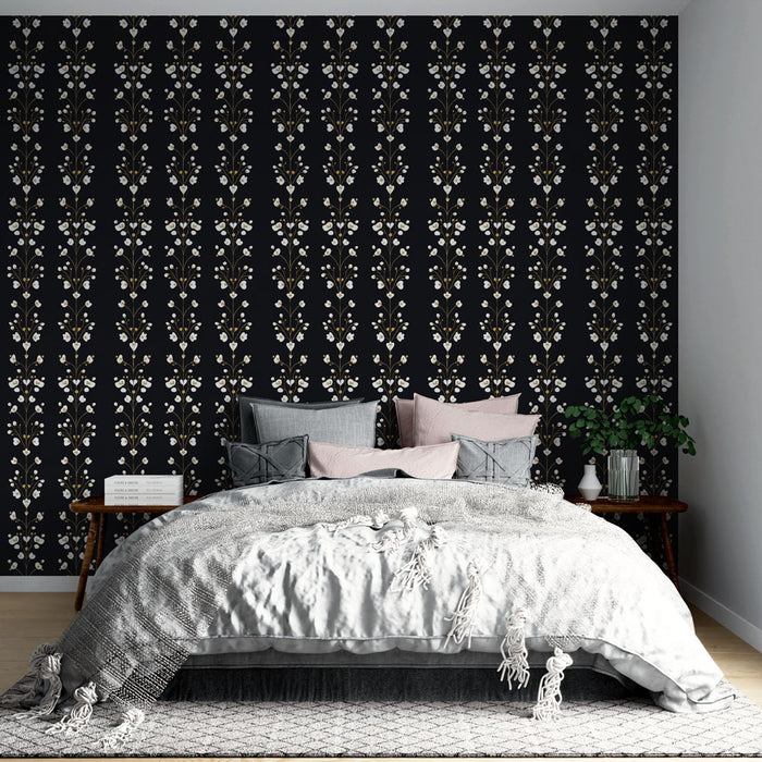 Une chambre élégante avec un papier peint floral sur fond noir, orné de motifs blancs et dorés, créant une atmosphère chaleureuse et raffinée.
