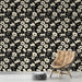 Une pièce moderne avec un papier peint floral noir et crème, aux motifs délicats, créant une ambiance élégante et chaleureuse.
