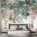 Une chambre lumineuse avec un papier peint floral représentant de grandes feuilles vertes et des grappes de fleurs roses, créant une ambiance apaisante et naturelle.