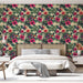 Une chambre lumineuse avec un papier peint tropical aux motifs floraux colorés, mêlant hibiscus roses et feuillage verdoyant, créant une ambiance vivante et accueillante.