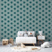 Une chambre d'enfant avec un papier peint bleu-vert aux motifs floraux stylisés, créant une ambiance douce et ludique.