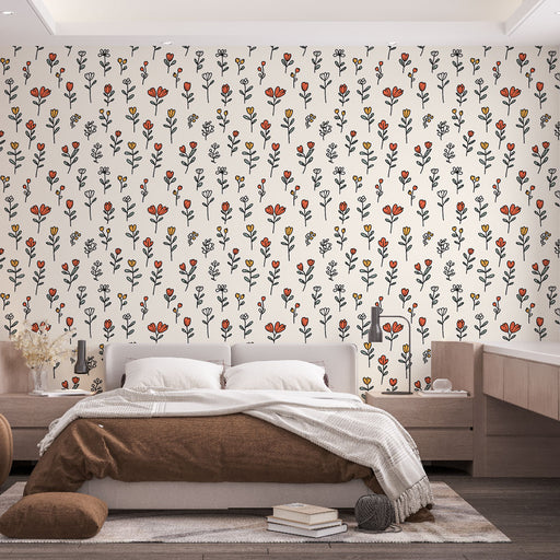 Une chambre chaleureuse avec un papier peint floral aux motifs colorés de fleurs rouges, jaunes et noires sur fond clair, créant une ambiance accueillante et joyeuse.