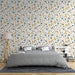 Une chambre apaisante avec un papier peint floral aux motifs de fleurs jaunes et bleues sur fond crème, créant une atmosphère douce et accueillante.