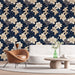 Un salon moderne avec un papier peint floral sur fond bleu nuit, orné de grandes fleurs crème et de feuillages, créant une ambiance élégante et apaisante.